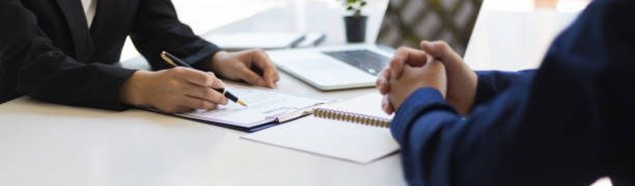 The manager is reading the resume and is interviewing the new employee. Negotiating business and signing a contract. Lawyer and legal advisor.