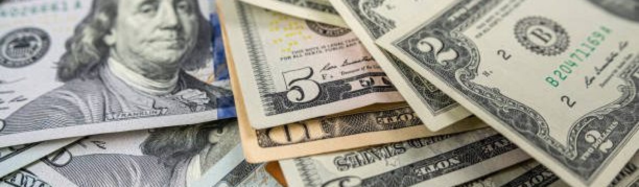 1 2 5 10 100 Different dollar bills in a pile as background. Finance concept